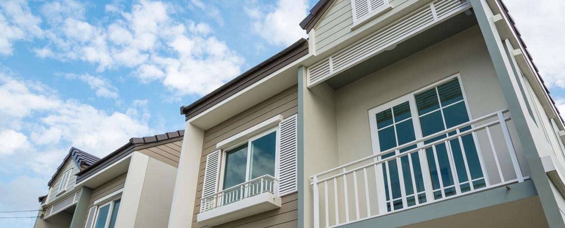 Front of house with blue sky and clouds above